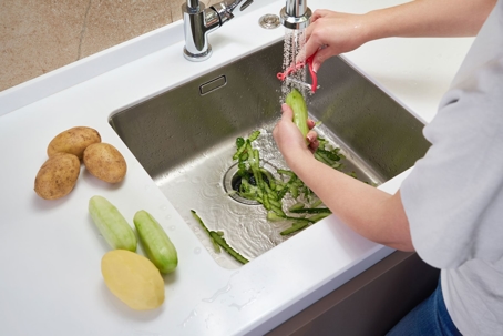 Man Cleaning vegetables in the sink